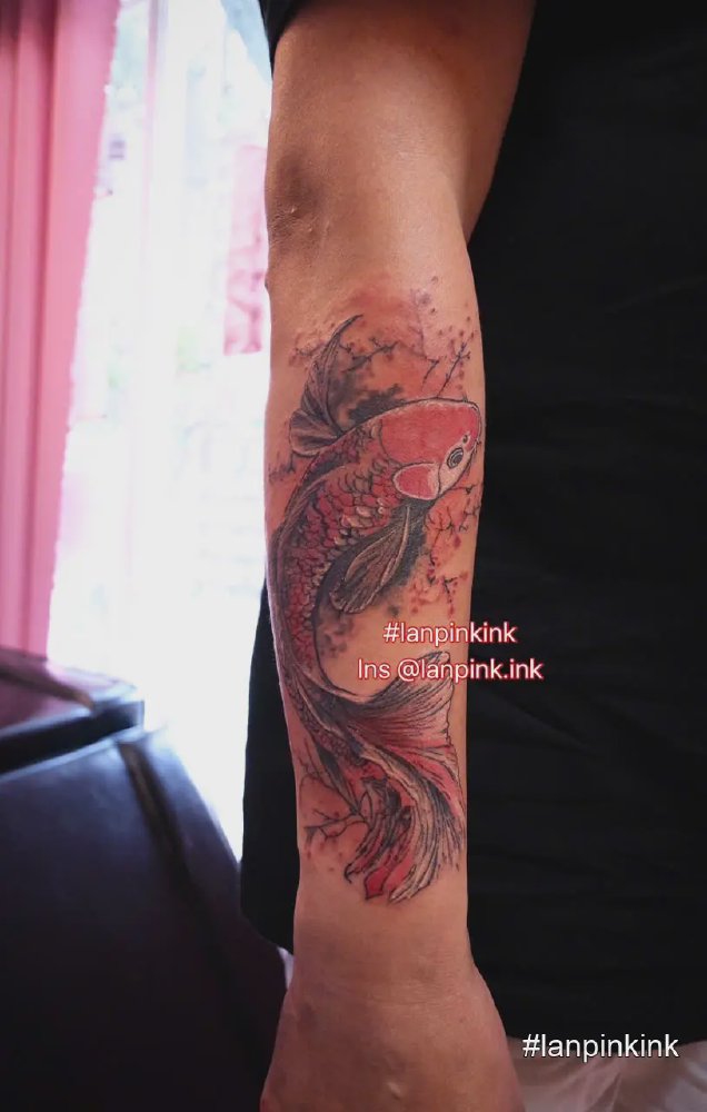 Hình xăm cá nghệ thuật trên cẳng tay với tông đỏ đen tại Lan Pink Tattoo