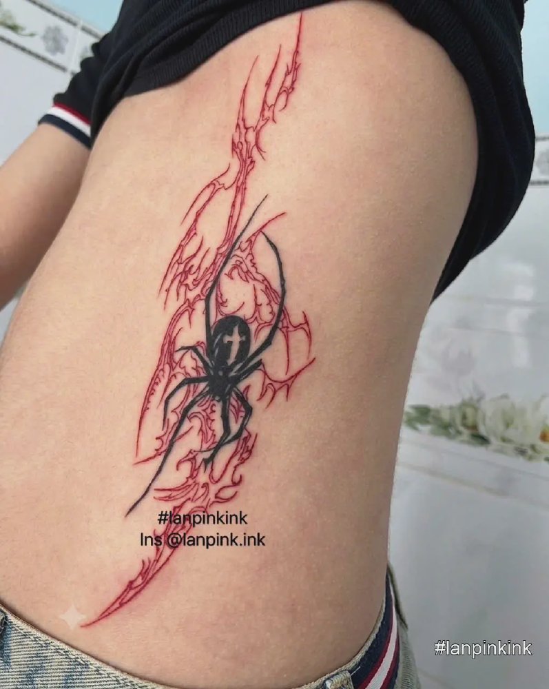 Hình xăm nhện đen nghệ thuật kết hợp đường nét đỏ trên eo khách nữ tại LanPinkTattoo