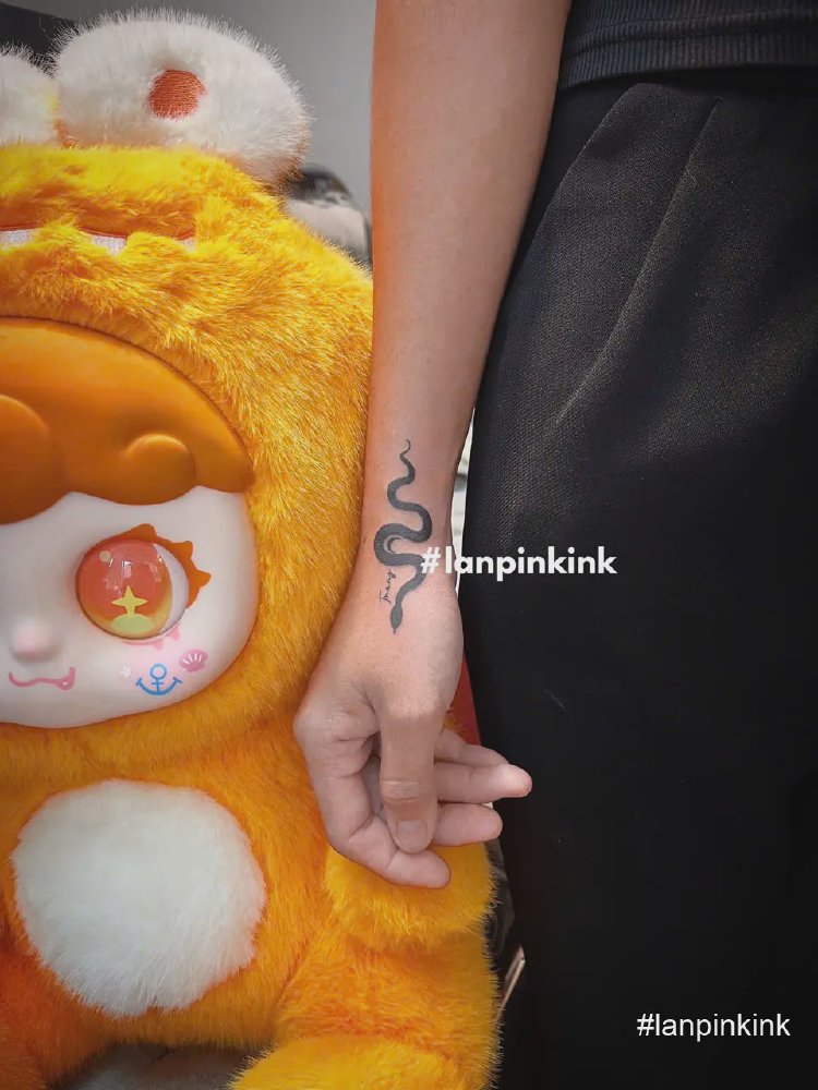 Hình xăm rắn mini màu đen ở mặt trong cổ tay thực hiện tại Lan Pink Tattoo Quận 12 TP.HCM